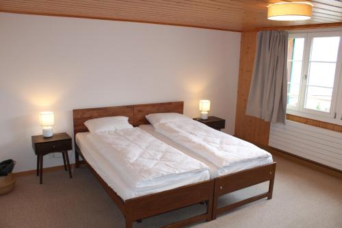a bedroom with a large bed with two night stands at Apartment Büel in Krattigen in Krattigen