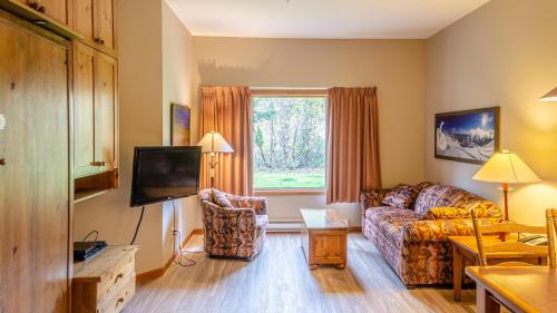 a living room with a couch and a tv at Cahilty #103 in Sun Peaks