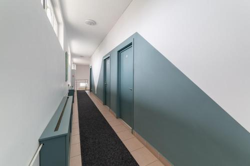 ein Flur mit grünen Türen in einem Gebäude in der Unterkunft Elizeu Hotel in Bukarest