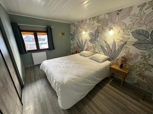 a bedroom with a large white bed with a floral wallpaper at Le Nid de Chartreuse in Saint-Christophe