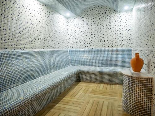 a bathroom with a tub with a vase on a table at Pera Aura Resort Hotel & Spa - All Inclusive in Kemer