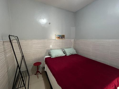 a small room with a bed with a red blanket at Hotel B&B in Santa Inês