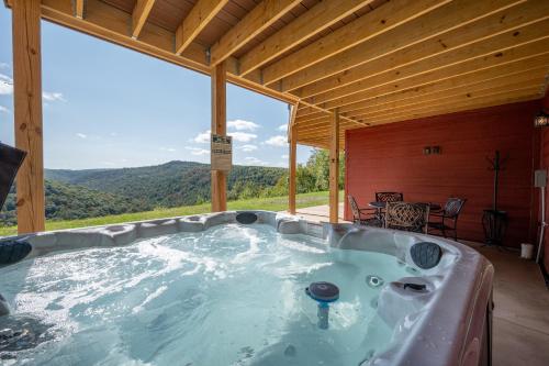 a hot tub in a cabin with a view of the mountains at Bear Cliff Lodge by Railey Vacations in Friendsville