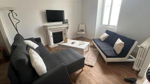 a living room with a couch and a fireplace at La demeure du 159 in Cognac