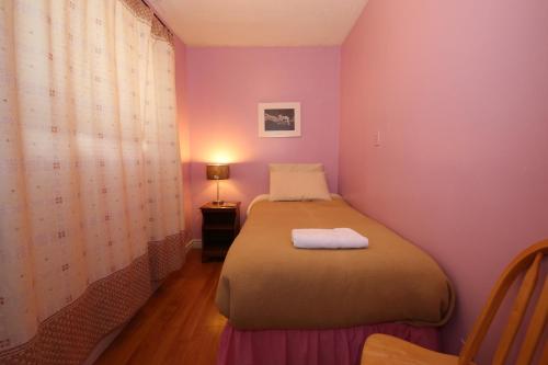 a bedroom with a bed in a room with purple walls at Jenny's Guest House in Yellowknife