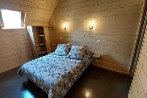a bedroom with a bed in a wooden room at La grange du vezou in Paulhenc