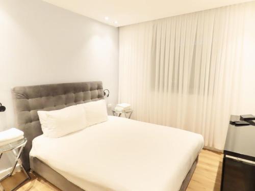 a bedroom with a large white bed and a window at THE white lotus in Eilat