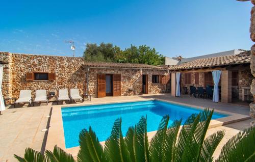 a swimming pool in front of a stone house at S'hortet in Campos