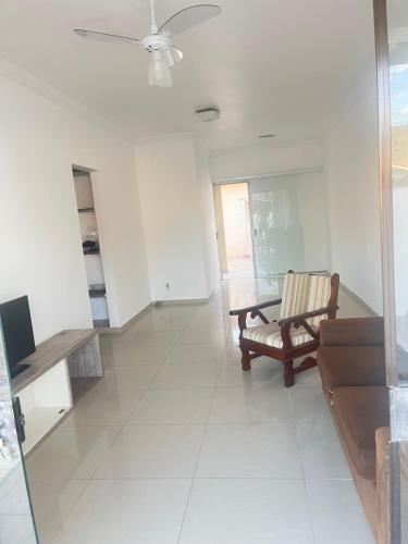 a living room with a chair and a table at Casa ilha comprida perto da praia in Ilha Comprida