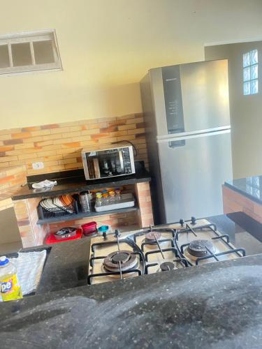 a kitchen with a stove and a refrigerator at Casa ilha comprida perto da praia in Ilha Comprida