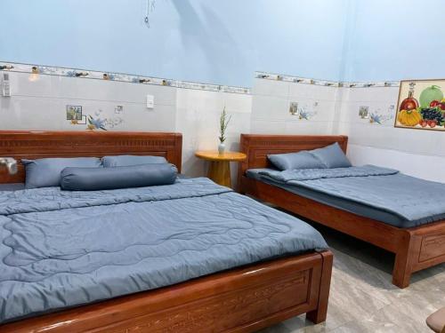 two beds with blue pillows in a bedroom at Con Cua Biển Homestay in Tuy Hoa