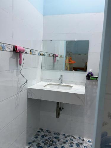 a white bathroom with a sink and a mirror at Con Cua Biển Homestay in Tuy Hoa