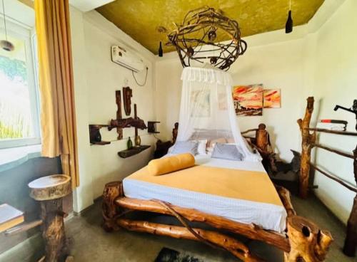 a bedroom with a wooden bed with a cage above it at SD3M ART GALLERY Villa in Dickwella