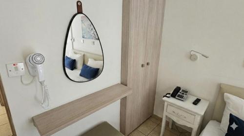 a bathroom with a mirror and a phone on the wall at NissiLant hotel & suites in Ayia Napa