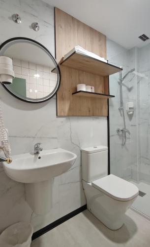 a bathroom with a sink and a toilet and a mirror at HOTEL RST. PADORNELO in Padornelo