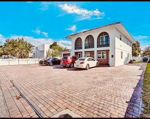 a building with two cars parked in a parking lot at House FLL airport in Fort Lauderdale