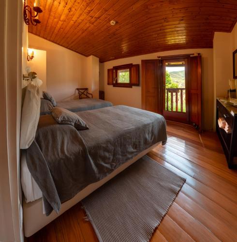 a bedroom with a large bed and a wooden ceiling at Bairro do Casal - Turismo d'Aldeia in Vila Nova de Foz Coa