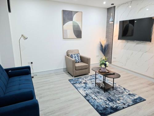 a living room with a couch and a chair and a table at New & Lovely Spacious 2-Bedroom Villa in Coventry