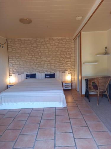 a bedroom with a large bed and a desk at Au Fil de l'Eau in La Ronde