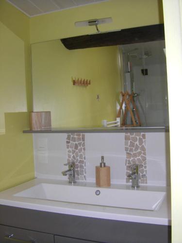 a bathroom with a sink and a mirror at Au Fil de l'Eau in La Ronde