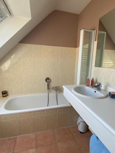 a bathroom with a bath tub and a sink at Charming Duplex in Knokke-Heist
