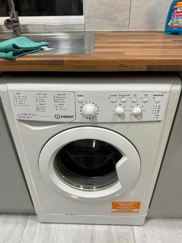 a microwave sitting on top of a washing machine at 96 Nelgarde Guesthouse in London