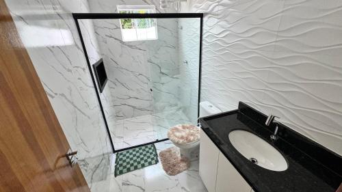 a bathroom with a shower and a sink and a toilet at Bela casa jacumã in Conde