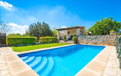 a swimming pool in a yard with a stone wall at Perla Sort Llarga in Moscari