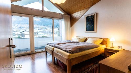 a bedroom with a bed and a large window at Holidayapartment Kirchweg, Glis in Brig
