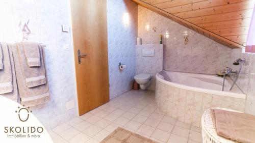 a bathroom with a bath tub and a toilet at Holidayapartment Kirchweg, Glis in Brig