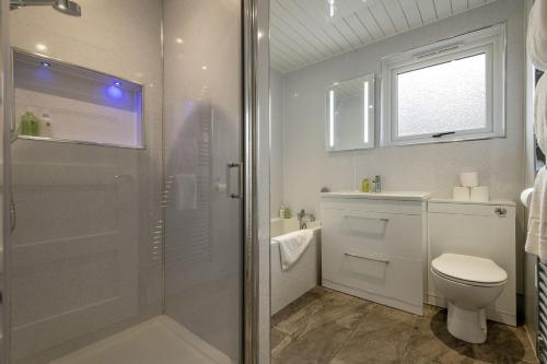 a white bathroom with a shower and a toilet at Admiralty Lane - No 4 in Elie