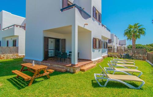 a row of lounge chairs on a lawn next to a house at Marina D'or Lv Casa 5 in Cala d´Or