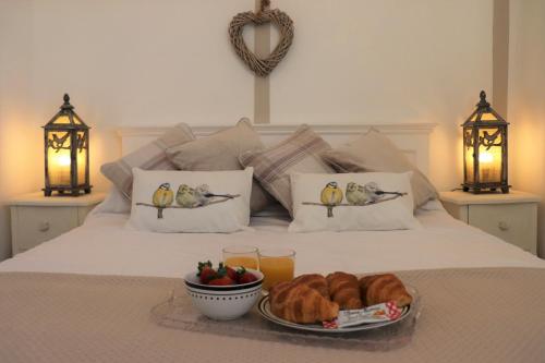 a bed with a tray of croissants and a plate of food at Beautiful Barn Conversion, 3 Bed, hot tub, sauna, gym, enclosed garden in Ryde