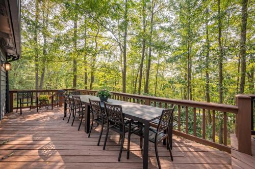 a table and chairs on a deck with trees at Black Bear Lodge by Railey Vacations in Oakland