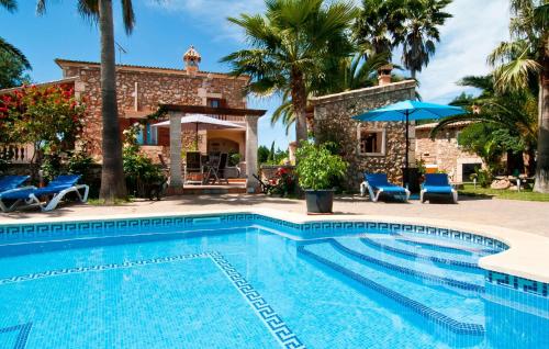 a pool in front of a house with palm trees at Can Lopez Vara in Campos