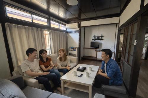 a group of people sitting in a living room at Nagasaki Night View Terrace Entire Home -Inasayama Panorama稲佐山夜景テラス in Nagasaki