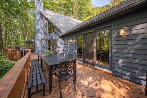 a deck with a table and chairs on a house at Black Bear Lodge by Railey Vacations in Oakland