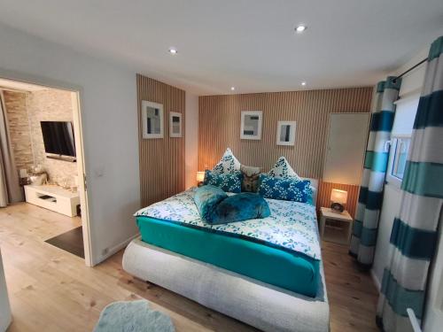 a bedroom with a bed with blue pillows at Ferienhaus Leon mit Sauna in Rehburg-Loccum