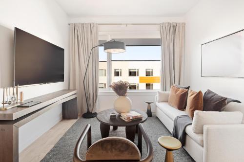 a living room with a couch and a tv at Hyatus Luxury Residences Boston Everett Premier Collection in Everett