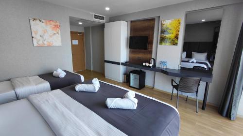 a hotel room with two beds and a desk and a bedroom at QUEEN PALACE HOTEL TRABZON in Trabzon