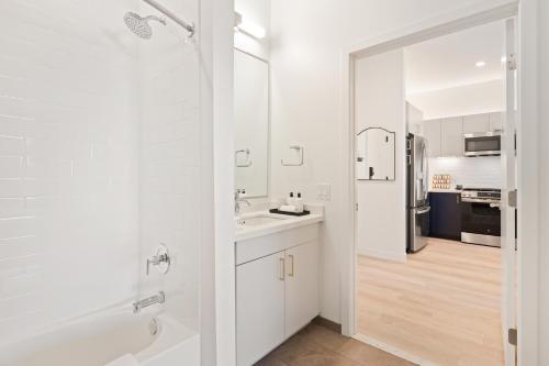 a white bathroom with a sink and a shower at Hyatus Luxury Residences Boston Everett Premier Collection in Everett