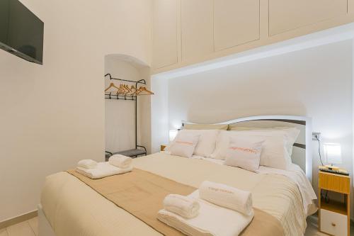 a white bedroom with two towels on a bed at Il borgo incantato in Bitonto