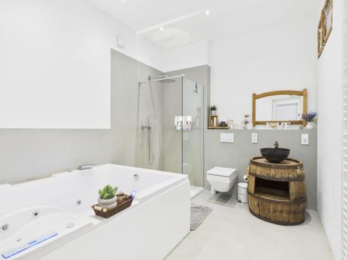 a bathroom with a tub and a shower and a toilet at Sam's Cottage Suite in Niederweis