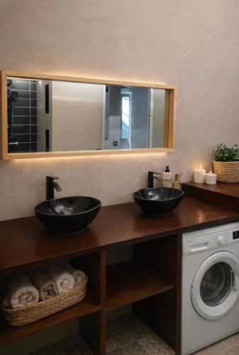a bathroom with two sinks and a washing machine at Casa Chiquinha in Ribeira da Prata