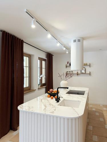 a white kitchen with a large white counter top at Sielski Dom in Suwałki