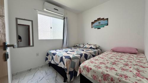 a small bedroom with a bed and a window at Bela casa jacumã in Conde