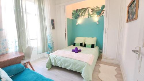 a room with a bed with a purple cross on it at Cosy Jade - Quartier Vivant du Chateau - Parking souterrain in Pau