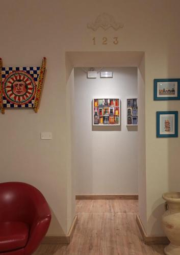 a room with a red chair and some pictures on the wall at amurimè in Porto Empedocle