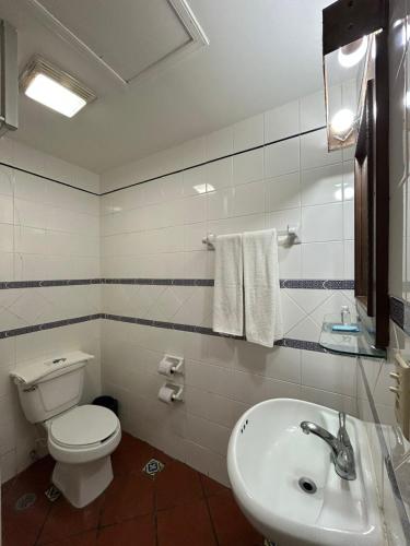 a bathroom with a toilet and a sink at HOTEL COLONIAL MATAMOROS in Matamoros