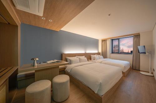 a hotel room with a large bed and a desk at 하로스테이 신사점 in Seoul